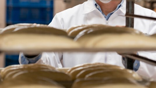 Baked goods on trays in rolling cage